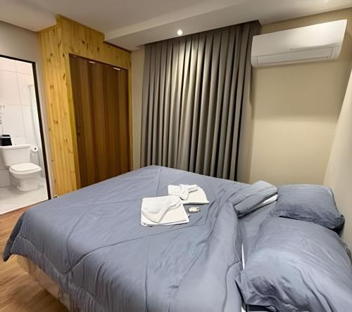 a bedroom with a bed with two towels on it at Joseph Prime Studio Hotel Extrema MG in Extrema
