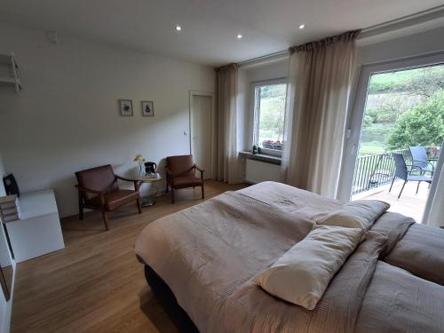 a bedroom with a large bed and a large window at B&B Haus Valmosa in Valwig