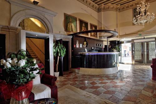 a lobby with a bar in the middle of a building at Ruzzini Palace Hotel in Venice