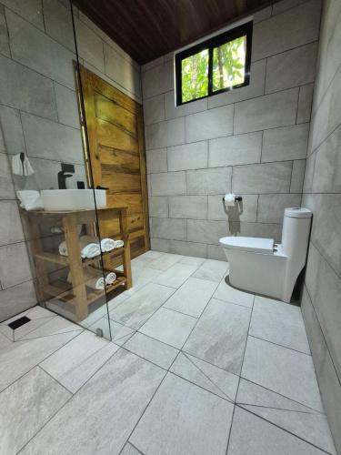 a bathroom with a toilet and a sink at Fauna Lodge in Drake