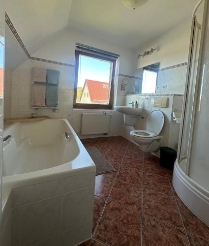 a bathroom with a tub and a toilet and a sink at Your home in Gohrisch in Kurort Gohrisch