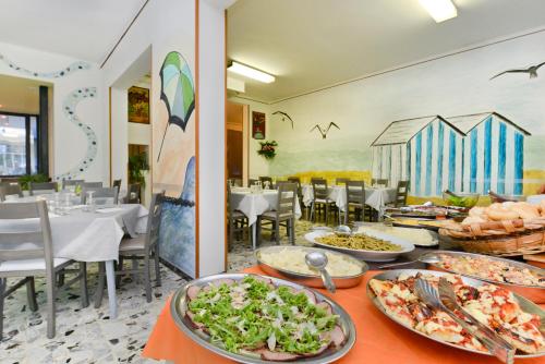 a buffet line with plates of food on a table at Hotel Flora in Cesenatico