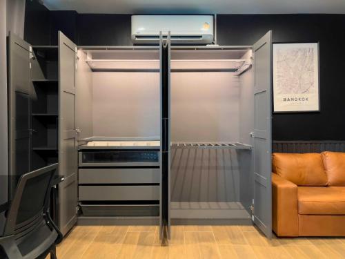 an empty refrigerator with a chair in a room at Toyatsu Residence in Pathum Thani