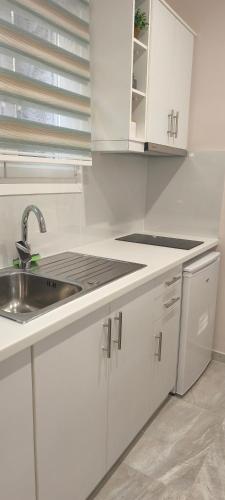 a kitchen with white cabinets and a sink at Sea Salt Apartments in Samos