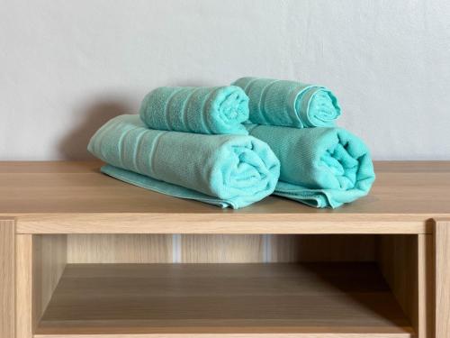 a pile of towels sitting on top of a shelf at Toyatsu Residence in Pathum Thani