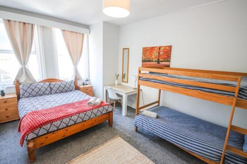 a bedroom with two bunk beds and a desk at Charming - 8ight Havens in Folkestone