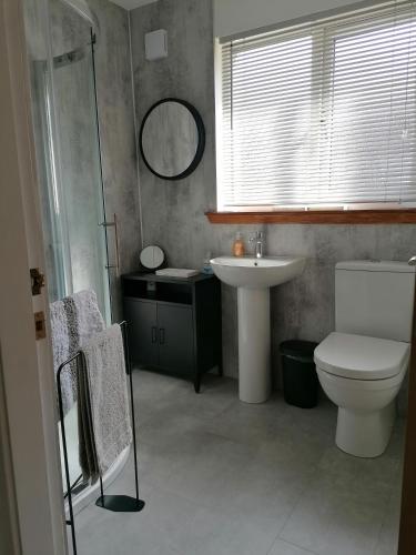 a bathroom with a toilet and a sink at House in Alness in Alness