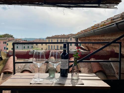a bottle of wine and two glasses on a table at Dimora 45, Contemporary Apartments in a Historic Building, Valdichiana, Tuscany in Sinalunga
