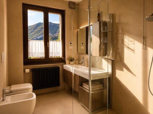 a bathroom with a sink and a toilet and a window at Villa La Perla, Bellagio in Bellagio