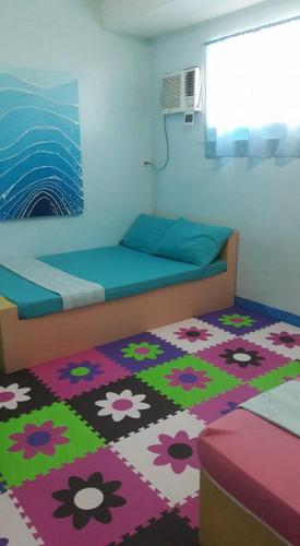 a bedroom with two beds and a rug with flowers at Gomez Guest House in Tagbilaran City