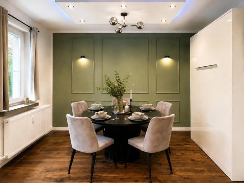 a dining room with a black table and chairs at Modernes Designer-Apartment in ruhiger Lage in Soltau