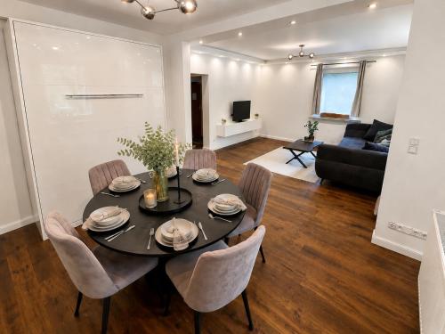 a dining room and living room with a table and chairs at Modernes Designer-Apartment in ruhiger Lage in Soltau