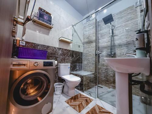 a bathroom with a washing machine and a sink at Les Jardins Anass 1 aéroport Marrakech in Marrakesh