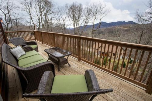 a deck with chairs and tables and a view of the mountains at Sugar Bear in Sugar Mountain