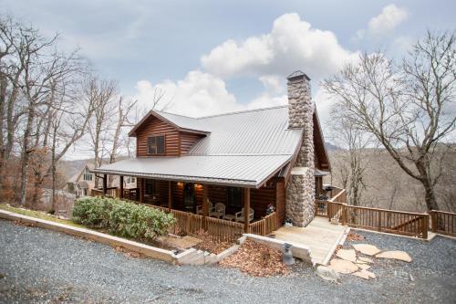 a log home with a porch and a chimney at Sugar Bear in Sugar Mountain