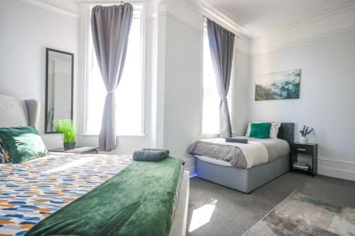 ein Schlafzimmer mit einem Bett und einem großen Fenster in der Unterkunft Spacious - 8ight Havens in Folkestone