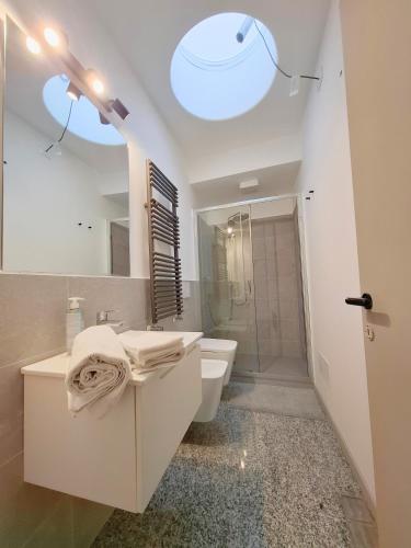 a white bathroom with a sink and a toilet at Eva Urban Rooms Centro Lecco in Lecco