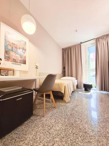 a bedroom with a bed and a desk and a chair at Eva Urban Rooms Centro Lecco in Lecco