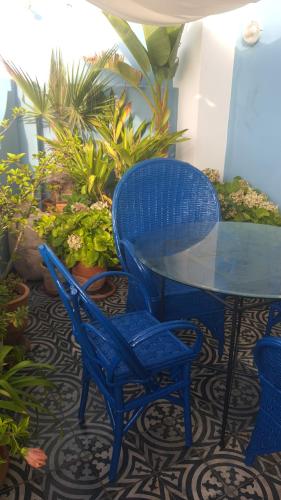 two blue chairs and a table and a table and some plants at Dar Moussa Assilah in Asilah