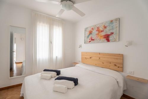 a white bedroom with a bed with towels on it at Villas 84 Est & Oest, Son Bou By MENORCARENTALS in Son Bou