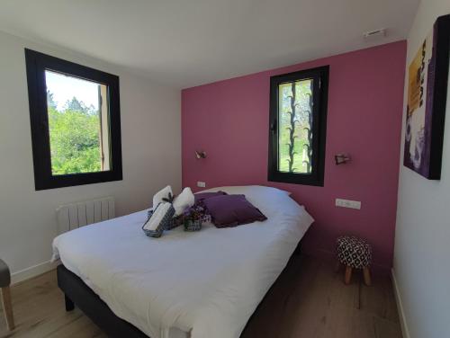 a bedroom with a large bed with purple walls at Le Bois Charmant in Lamonzie-Montastruc