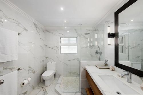 a white bathroom with a toilet and a sink at Southwinds - by ZenBreak in Saint Peter