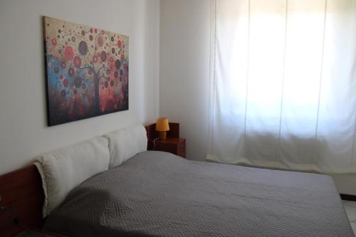 a bedroom with a bed and a painting on the wall at nido delle farfalle in Stazione di Chiusi