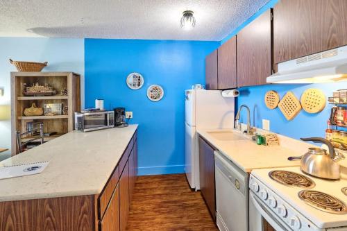 a kitchen with blue walls and a white refrigerator at Lovely Oceanfront Condo -Top Floor - Pet Friendly in Lincoln City