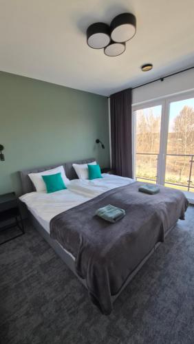 a large bed in a bedroom with a large window at Oaza Brzozowa in Stradomia Wierzchnia