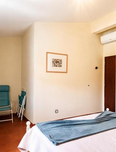 a bedroom with a bed and a picture on the wall at Casa à Porta do Torreão in Silves