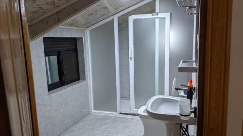 a bathroom with a white toilet and a sink at Mansarda Park View Hotel in Nyagatare