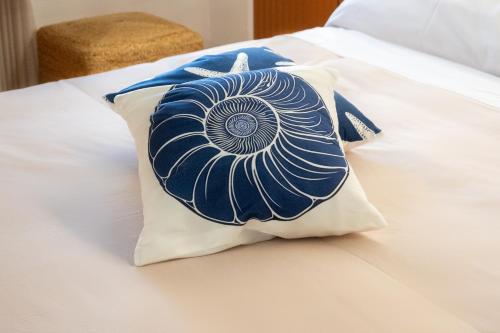 a blue and white pillow on a bed at Vira Verso Est in Otranto