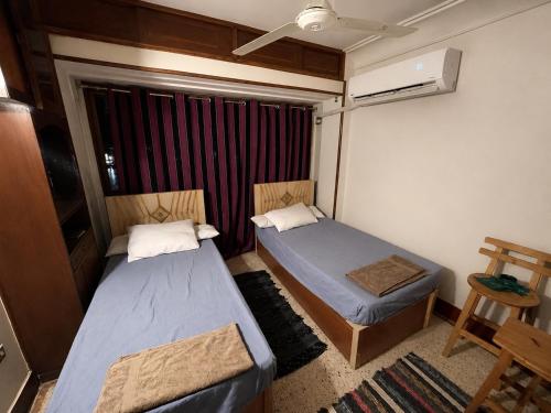 a small room with two beds and a window at Nile View Studio Aswan in Aswan