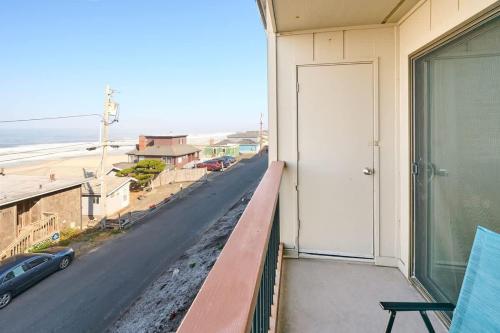 a balcony with a door and a view of a street at Oceanfront Condo - Second Floor - Pet Friendly in Lincoln City