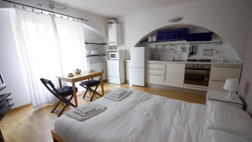 a bedroom with a bed and a table and a kitchen at Italianway-Forcella in Milan