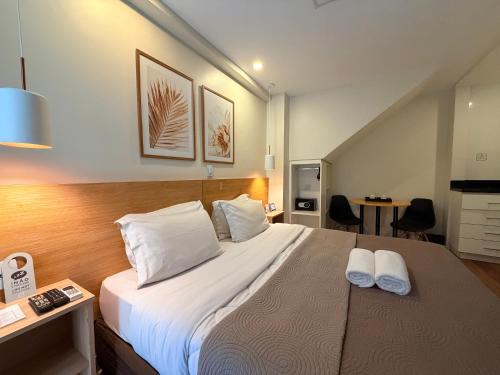 a bedroom with a large bed with two pillows at Injoy Suítes & Aparts in Rio de Janeiro