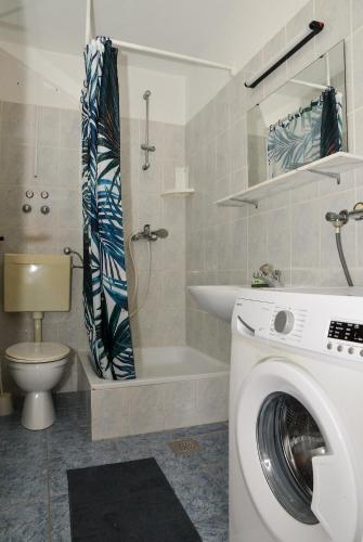 a bathroom with a washing machine and a toilet at Blagdan Holiday in Kukljica