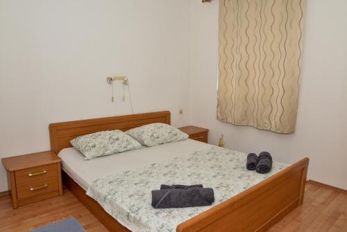 a bedroom with a bed with a pair of shoes on it at Blagdan Holiday in Kukljica