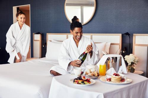 a man sitting on a bed with a plate of food at The Clayfield, in the Unbound Collection by Hyatt in Niagara-on-the-Lake