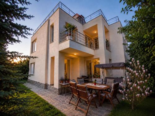 a house with a table and chairs in the yard at Villa Avelia - Sea View Jacuzzi Retreat in Varna City