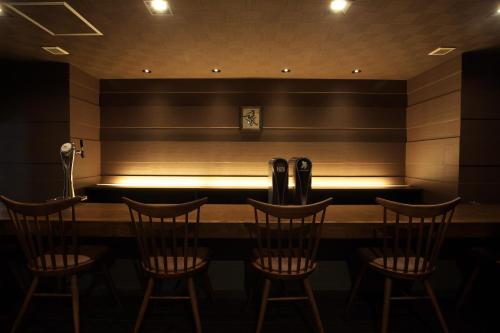 a bar with chairs and a bench in a room at Matsuya Bekkan in Kumamoto