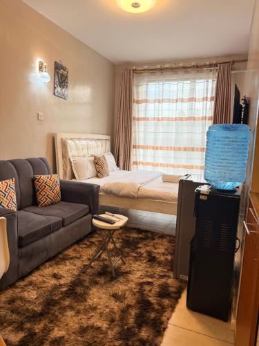 a living room with a couch and a bed at HIDEOUT BnB with swimming pool in Kiambu