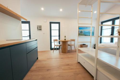 a kitchen with white cabinets and a dining room with a table at Villa Eva in Ajdovščina