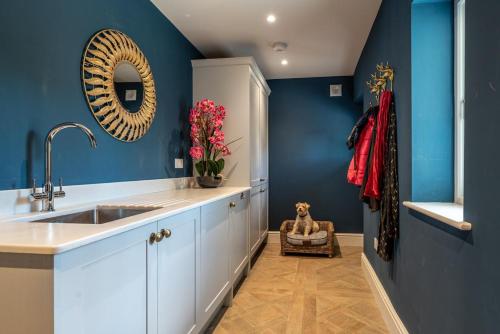 a kitchen with a sink and a blue wall at 5 Bed in Hereford oc-83658 in Madley