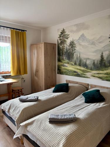 two beds in a bedroom with a painting on the wall at Dunajecki Zakątek z Jacuzzi in Biały Dunajec