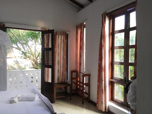 a room with a bed and two windows and a bed sidx sidx sidx at Dephani Beach Hotel in Negombo