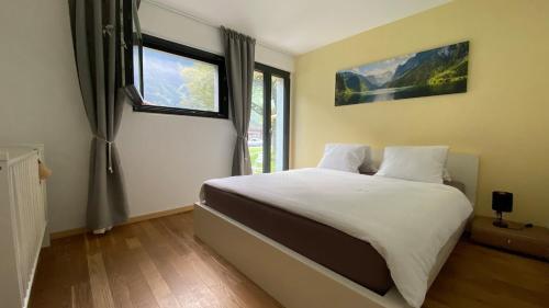 a bedroom with a large white bed with a window at Falke-Apart 1 am Wasserfall in Unterbach