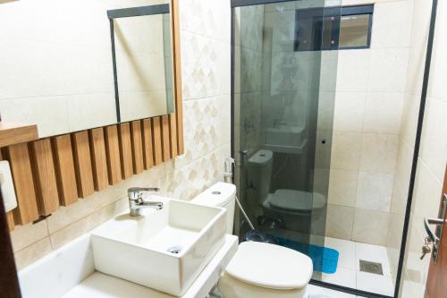 a bathroom with a sink and a toilet and a shower at New Apart Hotel Ciudad del Este in Ciudad del Este