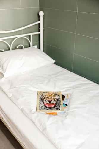 a book sitting on a white bed at Simple Stay - Fresh Start May 2026 in Nice