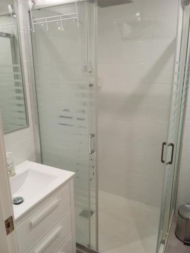 a white bathroom with a shower and a sink at Elviria Beauty by the sea in Marbella
